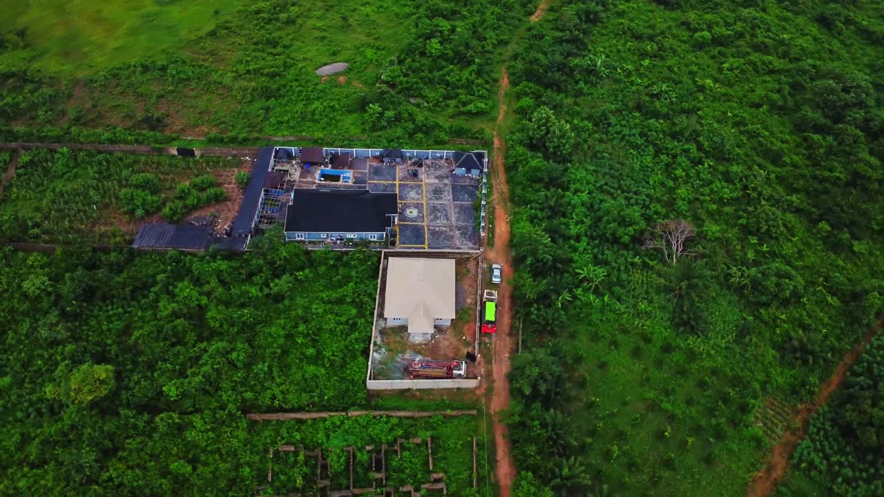 Aerial of a small agricultural business surrounded by beautiful green nature in rural Nigeria, Africa