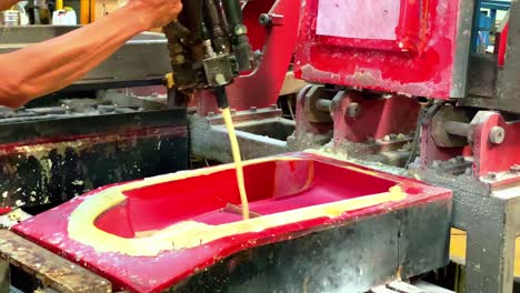 Man-uses-industrial-foam-making-machine,-sprays-liquid-in-mold,-slowmotion