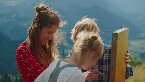 mother painter teaching children draw outdoor. happy family creating picture.