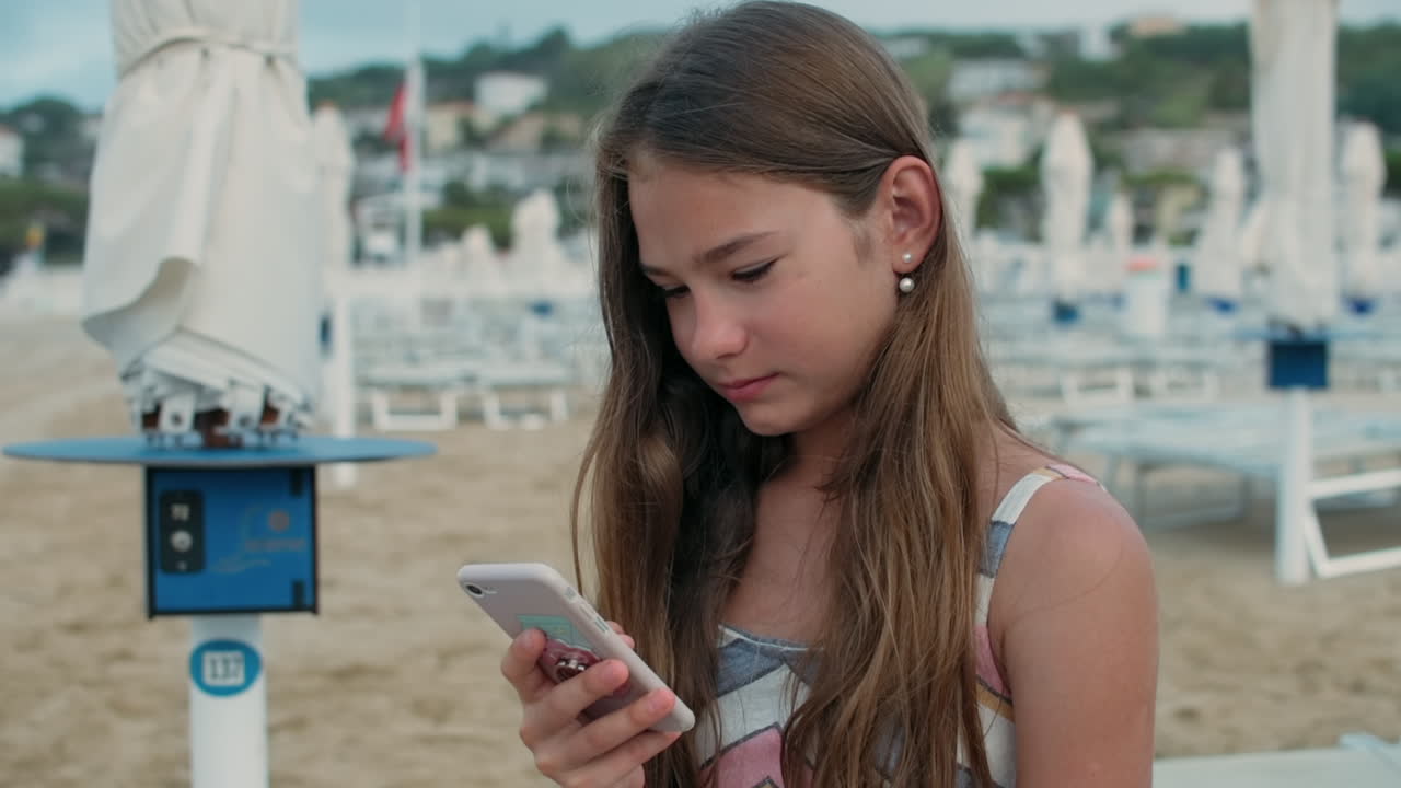 mujer feliz pasando el tiempo en la playa. niña leyendo un mensaje en su teléfono inteligente.
