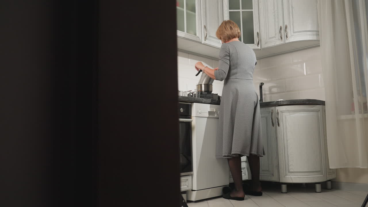 Lady seen from behind dancing and cooking in modern kitchen, stirring with one hand while enjoying her cooking experience, casual and joyful atmosphere in well-lit kitchen