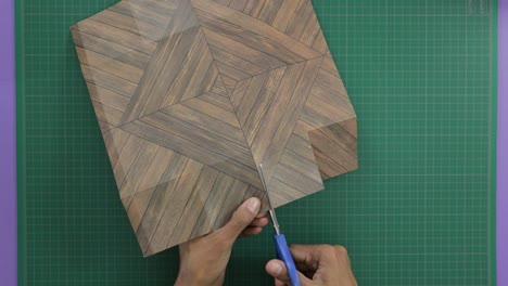 carefully cutting the sides of wood craft paper for gifting with scissors