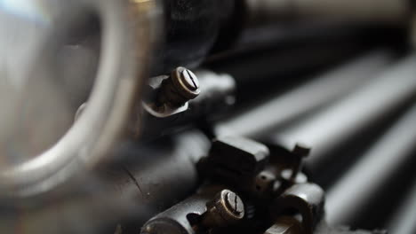 Detail-of-an-original-Heidelberg-cylinder-printing-machine,-parts-moving-in-background-paper-is-sliding-on-the-rollers