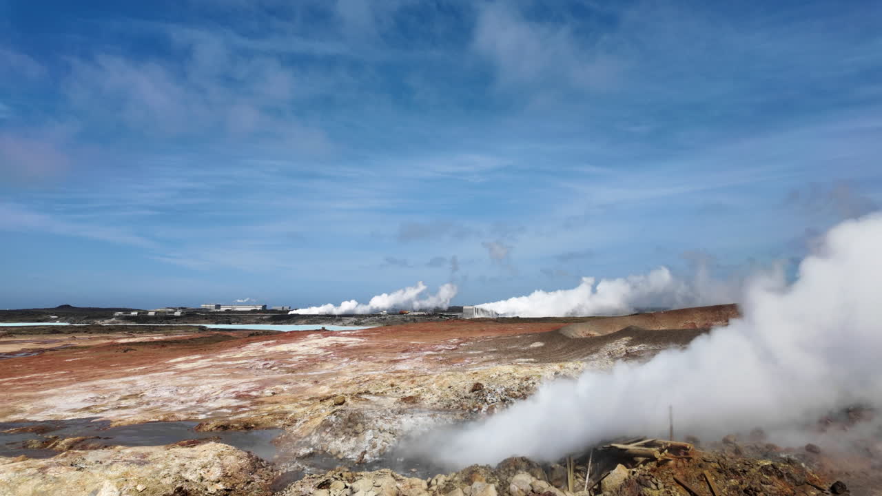 Natural steam rising from a geothermal field under blue sky in the countryside environment of Iceland