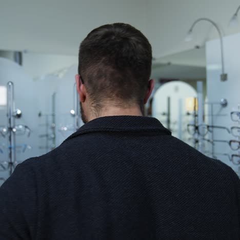man in optical shop trying eyeglasses