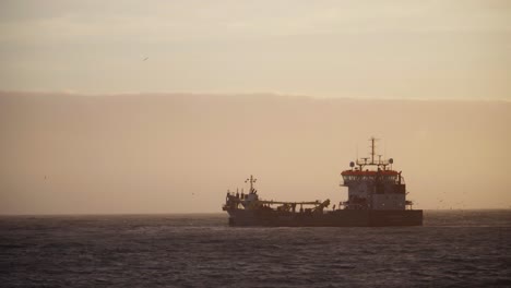dredger ship at sea during sunset