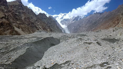 Aerial-shot-of-hiker-standing-at-glacier-at-Fairy-Meadows-Pakistan,-cinematic-slowly-rising-drone-shot