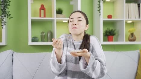 그리고 행복하고 귀여운 아시아 젊은 여성이 요구르트를 먹고 있습니다.