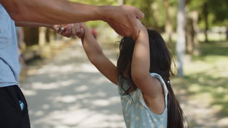 close-up of little asian girl walking with father holding hands