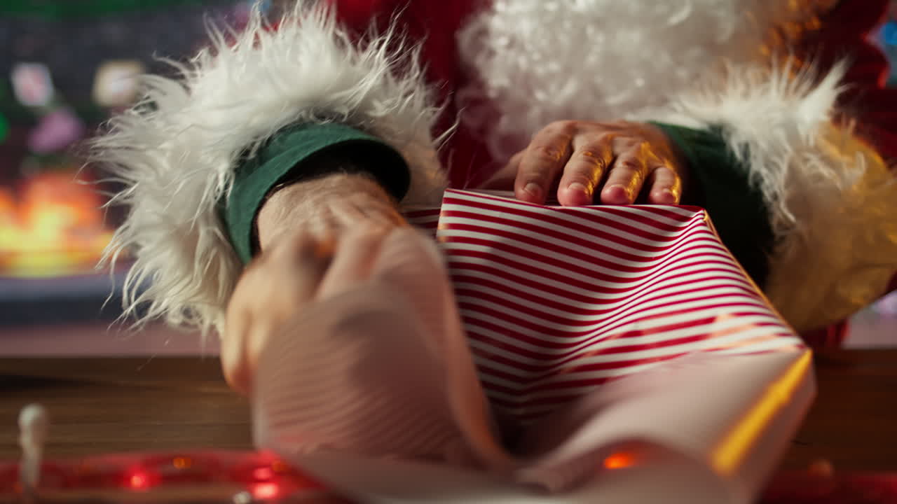 Santa wrapping a Christmas gift