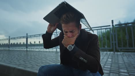 man stressed out by wet laptop