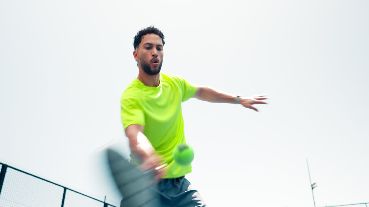 Man Serving Padel Ball on an Outdoor Court