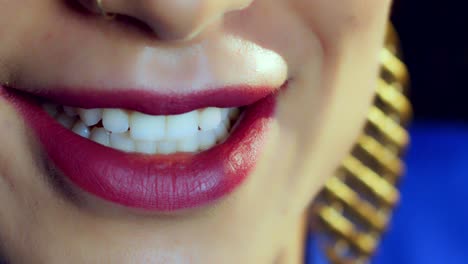 sonrisa de mujer con pintalabios rojo y piercing en la nariz, de cerca