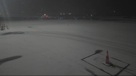 fixed shot of empty airport ramp covered in snow