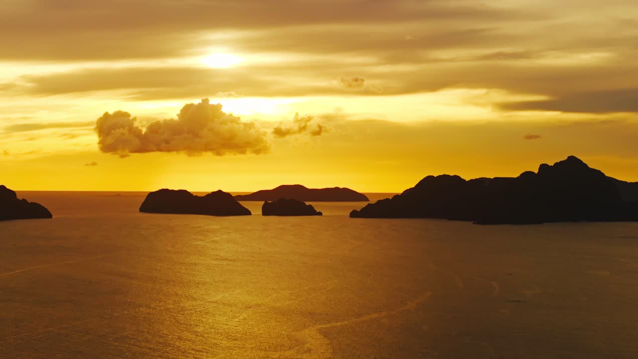 Parlayan bulutların ve El Nido deniz ufkunun arasından sinematik yana doğru drone hareketi.