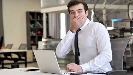 joven empresario en estado de shock mirando a la cámara