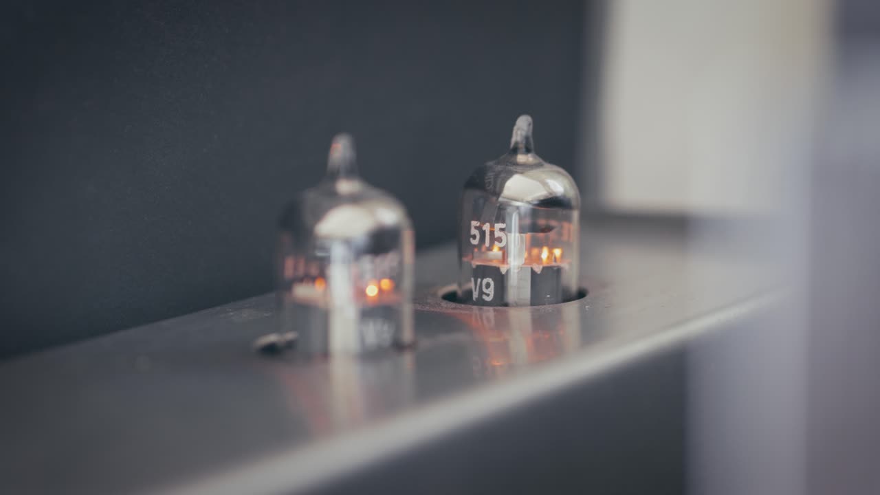 Turning on power vacuum tube amplifier. Electronic device amplifier with glowing bulb, old-fashioned. Scene A.