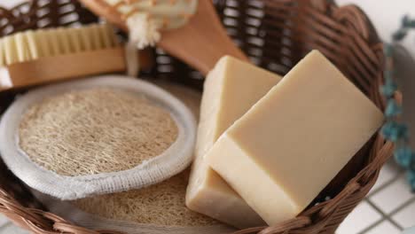 jabón natural y loofah en una canasta de mimbre