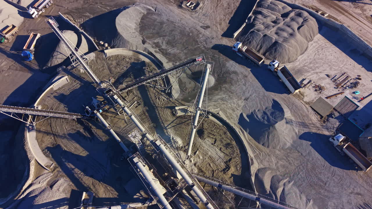 Vast industrial landscape showcases machinery at work transporting materials under bright daylight
