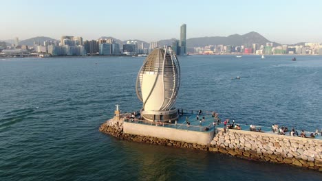 people walking on a breakwater with central wanchai bypass east vent shaft in causeway bay, hong kong