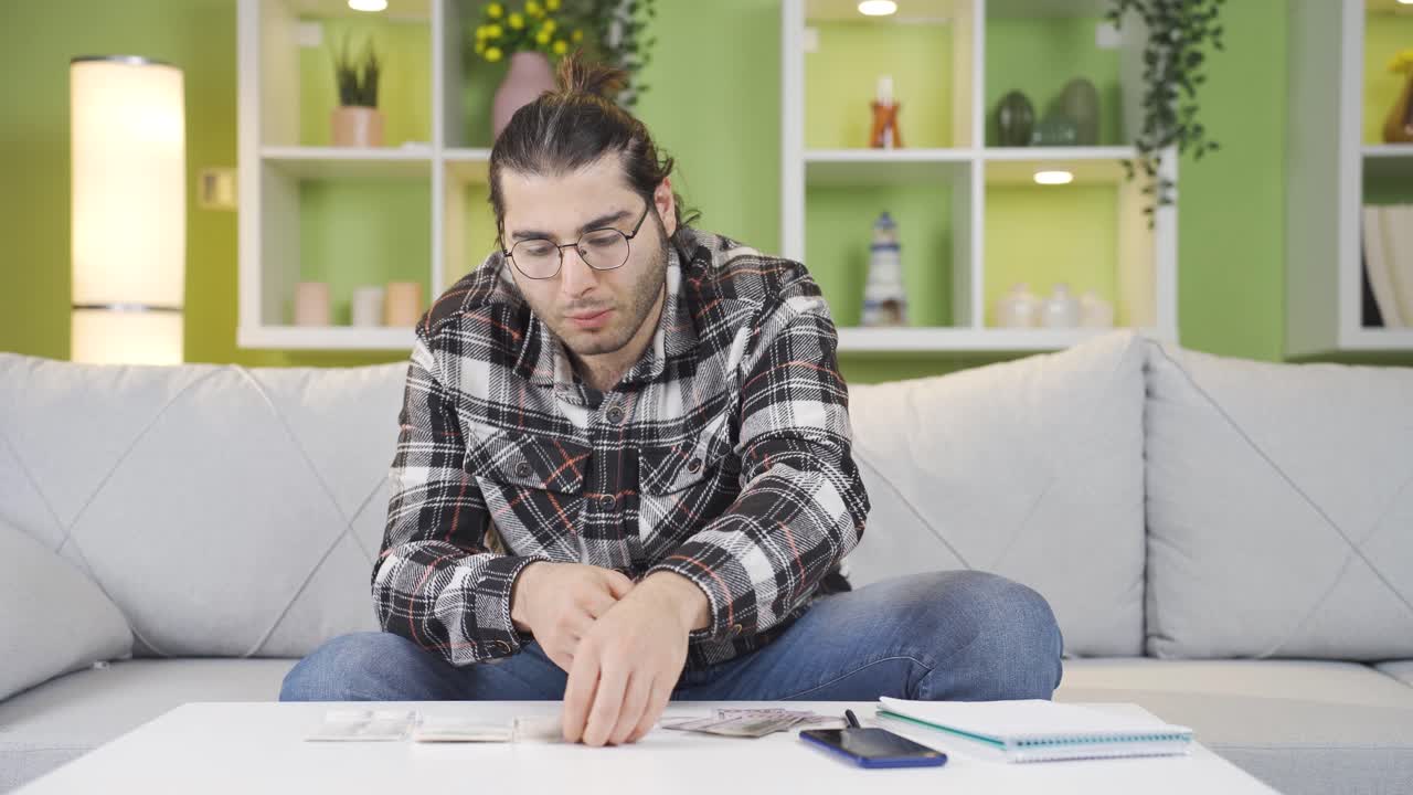 un joven confundido mirando una factura sobrevalorada.