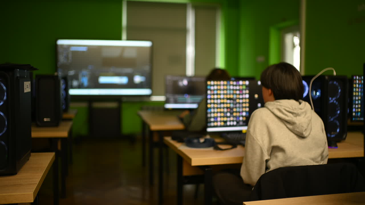 Chisinau, Moldova - March 15, 2026: Young student sitting at computer in a modern classroom with multiple monitors