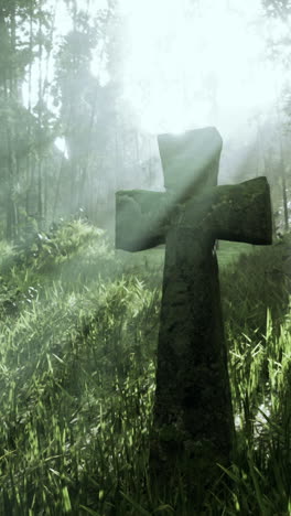 stone cross in a foggy forest