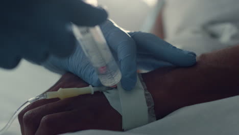 doctor putting patient iv doing injection closeup. hospital intensive care unit