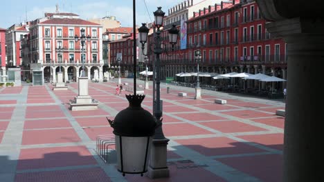 close-up of a traditional street light in valladolid’s historic plaza mayor, spain’s first permanent square, with the town hall visible on a hot summer day under a clear blue sky