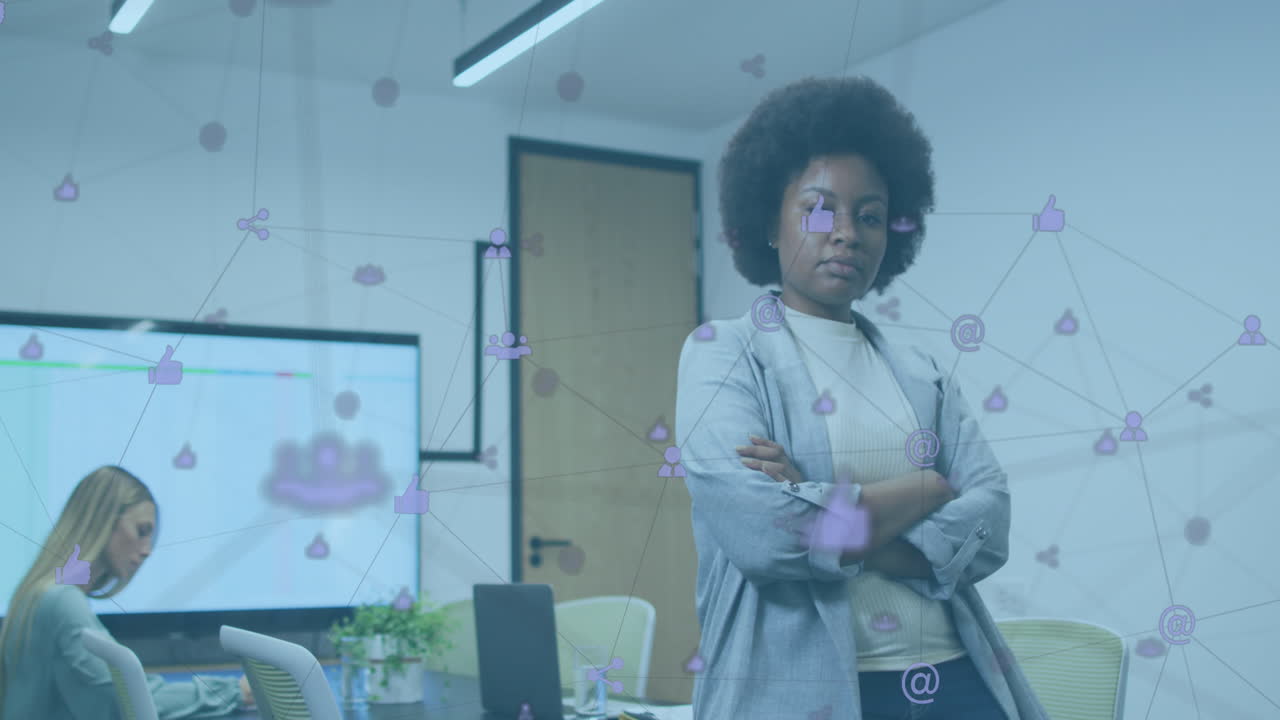 Animazione di rete di icone digitali su donna afroamericana con le braccia incrociate in ufficio