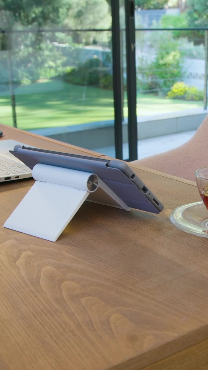 Vertical video: Panning camera showing purple tablet on desk by doors to show room, copy space