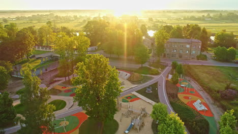 aerial tracking shot of a kids playground park on a colorful summer sunset