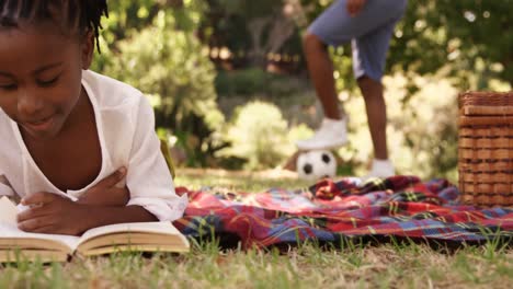 cute girl is reading a book in the park