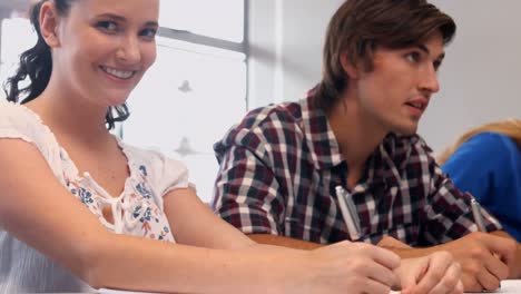 focused students taking notes in class at the university