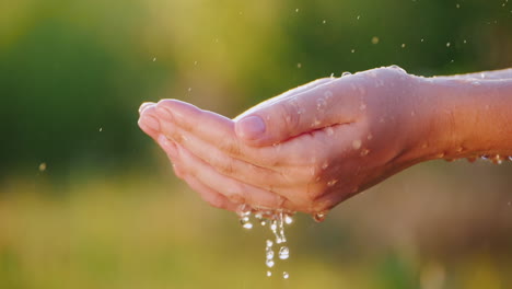 Hände-Fangen-Wassertropfen-Vor-Grünem-Hintergrund