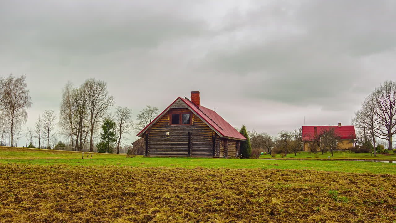 Time-lapse af landlig idyl med naturskøn tømmergård, mens stormskyer samles