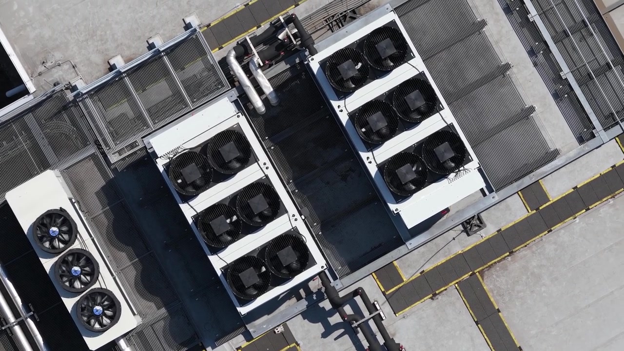 Luftfoto af store datacenters tagmonterede HVAC-kølesystemer, der viser colocation-infrastruktur, cloud computing, big data, maskinlæring og AI-hardwareteknologi.