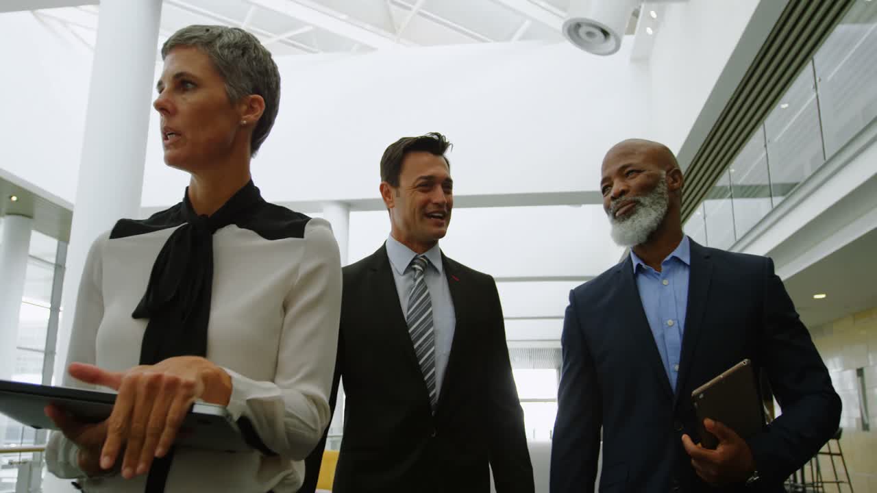 Business people discussing while walking in the office 4k