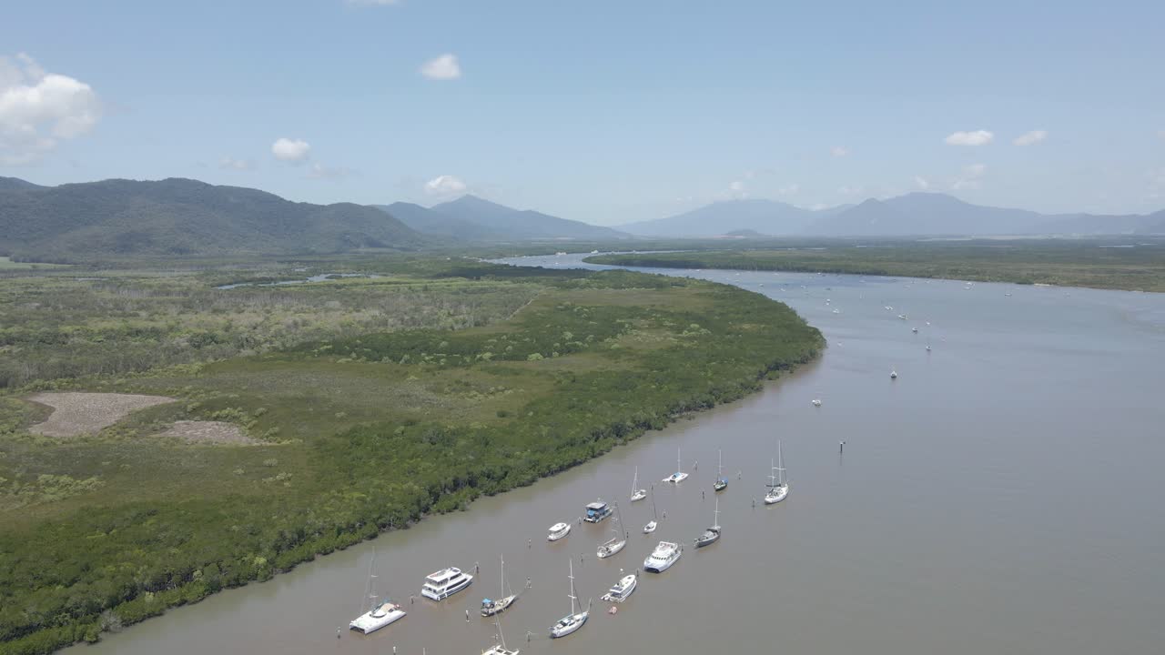 fila de barcos anclados en chinaman creek con la reserva forestal trinity - reserva natural cerca de cairns, australia