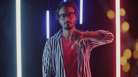 man giving thumbs down in neon light