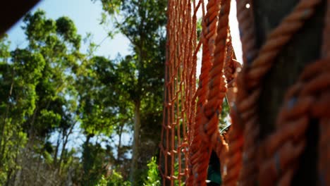 determined women climbing a net during obstacle course