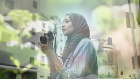 animation of asian woman in hijab with camera over cityscape