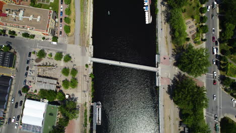 Aerial-view-tilting-over-the-Canal-de-Lachine,-toward-the-Saint-Lawrence-river,-in-sunny-Montreal,-Canada