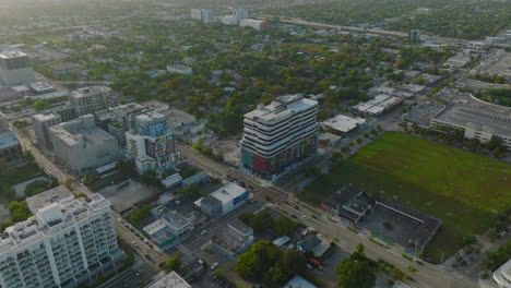 Fliegen-Sie-Bei-Sonnenuntergang-über-Häusern-Und-Mehrfamilienhäusern-In-Städtischen-Bezirken.-Neigung-Der-Straßenkreuzung-Nach-Unten.-Miami,-USA