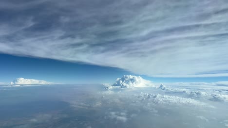 impresionante punto de vista del piloto mientras volaba a 12000 metros de altura volando entre capas de nubes con un cúmulo por delante, luz del día