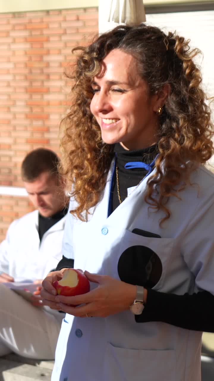 Medical Professionals Sharing an Apple Outdoors