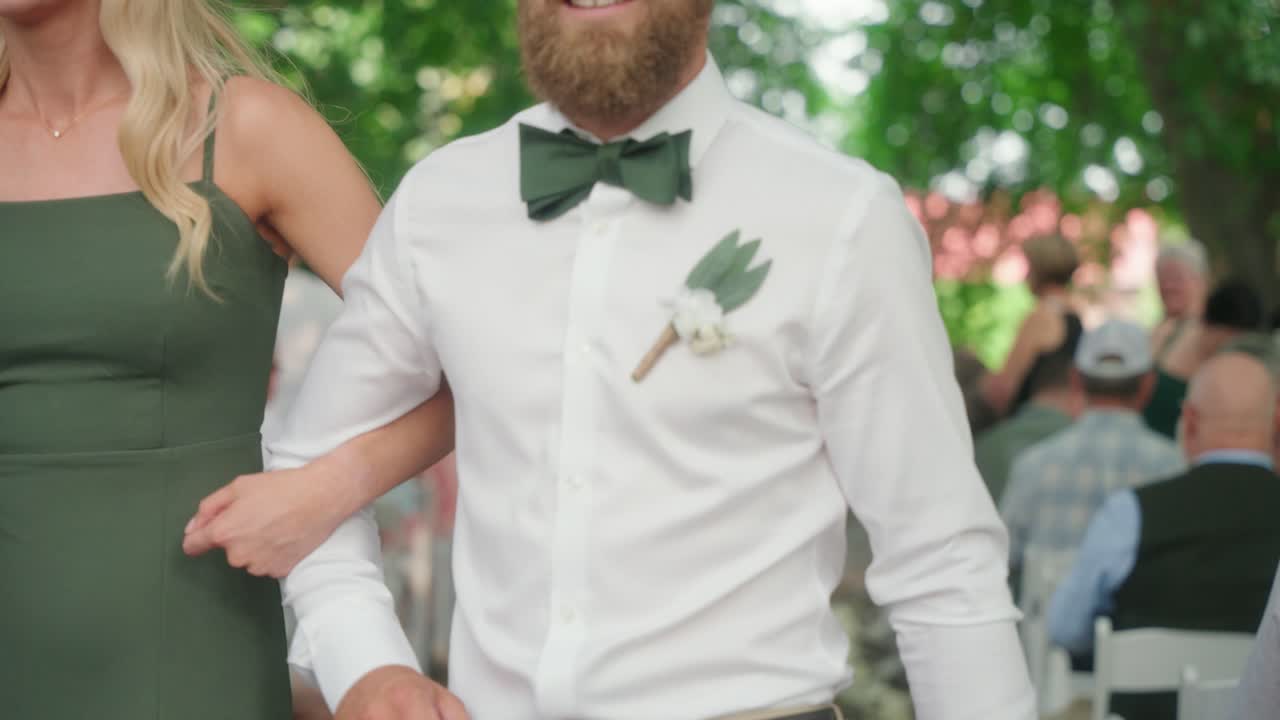 Bridal party walks down the aisle in pairs after the ceremony as guests remain seated.