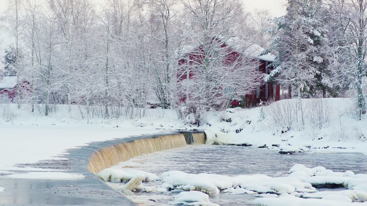 Small dam in the river on a cold and snowy winter day