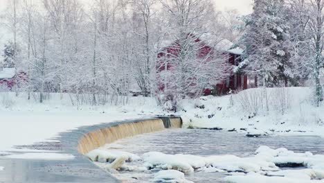 small dam in the river on a cold and snowy winter day