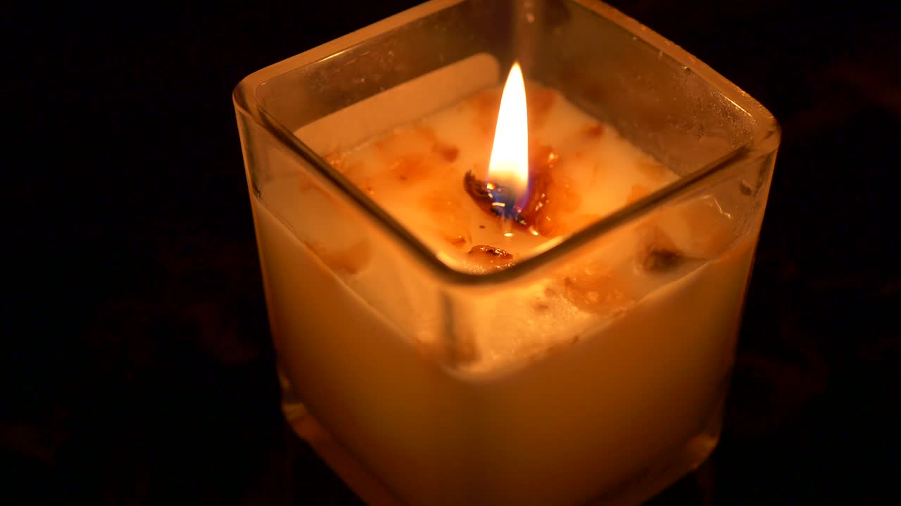 Candela accesa in un supporto di vetro